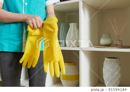 Cleaner girl wearing gloves before cleaning 91594184