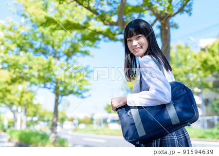 街道の帰り道で振り返る笑顔の女子高校生 通学 登下校 将来進路 青空 緑あふれる街の道 街道の帰り道で振り返る笑顔の女子高校生 通学 登下校 将来進路 青空 緑あふれる街の道 91594639