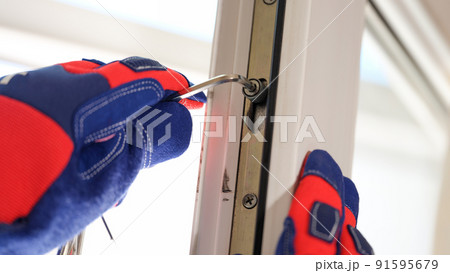 Master in gloves adjusting locks of pvc windows with special key 91595679