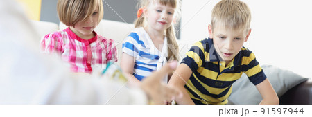Kids sitting on sofa and play card game together for development Kids sitting on sofa and play card game together for development 91597944