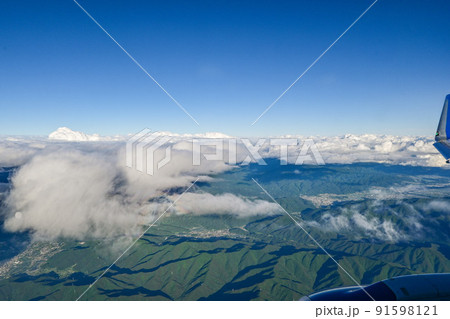 曇天の下、飛行機から北アルプスの山々を眺める　雲の合間から眺める長野県松本市 91598121