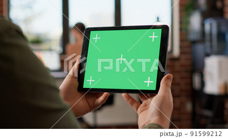 Startup manager looking at horizontal greenscreen on digital tablet, working with blank copyspace template and mockup display. Using isolated chroma key background on gadget. Close up. Startup manager looking at horizontal greenscreen on digital tablet, working with blank copyspace template and mockup display. Using isolated chroma key background on gadget. Close up. 91599212