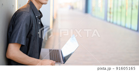 パソコンを持った男性　顔なし　カジュアルファッション 91605165