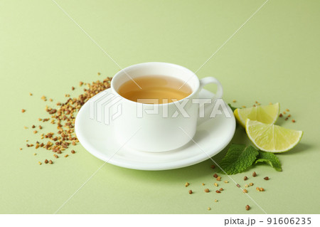 Concept of hot drink with buckwheat tea on green background Concept of hot drink with buckwheat tea on green background 91606235