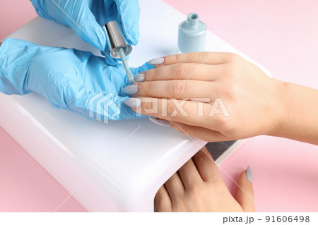 Nail care procedure on pink background, close up Nail care procedure on pink background, close up 91606498