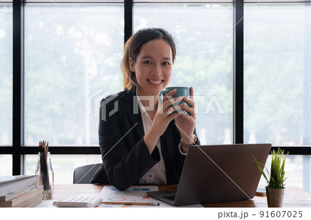 Business accountant woman using calculator with computer laptop, Business accounting, budget and loan paper in office. 91607025