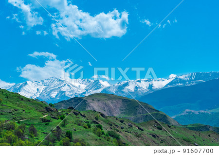 mountain landscape of the North Caucasus, a snow-covered ridge far beyond the alpine meadows 91607700
