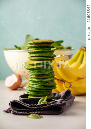 Spinach pancakes stack on blue background, food and drink 91608342