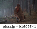 Young red-haired girl in medieval knight's armor in summer forest 91609541
