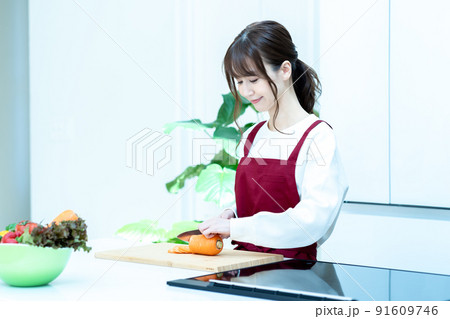 キッチンで料理をするエプロン姿の女性 91609746