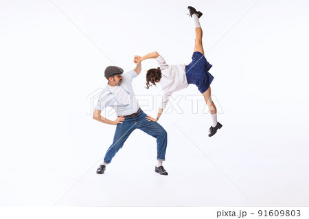 Portrait of cheerful couple, man and woman, dancing boogie woogie isolated over white studio background 91609803