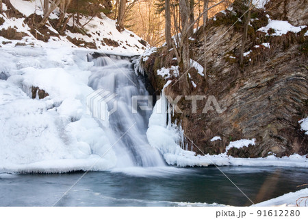 A small active waterfall. Clean mountain stream, snowy winter landscape, wildlife background A small active waterfall. Clean mountain stream, snowy winter landscape, wildlife background 91612280