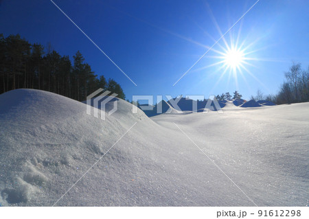 Wonderful winter landscape. Beautiful morning landscape of small snowy hills in winter. Frosty sunny morning. The beauty of winter and the warmth of the sun. 91612298