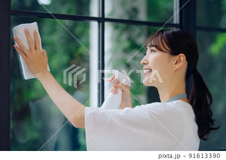 窓を掃除する若い主婦の家事イメージ 91613390