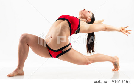 Sporty beautiful young woman practicing yoga, doing lunge exercise, Revolved Side Angle Pose, , working out wearing red and black sportswear, studio full length, isolated white background. Sporty beautiful young woman practicing yoga, doing lunge exercise, Revolved Side Angle Pose, , working out wearing red and black sportswear, studio full length, isolated white background. 91613465