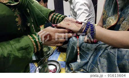 A sister is binding rakhi on her brother hand on the festival of raksha Bandhan 91613604