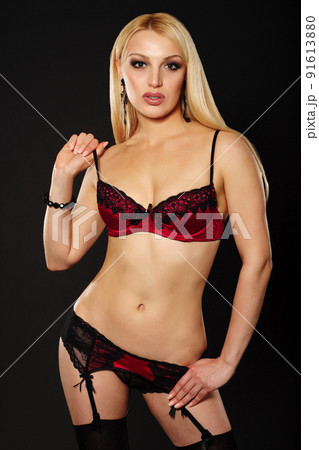 Beautiful Young Caucasian Woman, In Her Twenties, With Blonde Hair, Wearing Sexy Black Lingerie And Stockings, Isolated On black 91613880