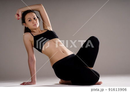 Young, fit and beautiful brunette woman in sportswear isolated on grey. Health care, diet, sport and fitness concept. 91613906