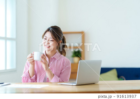 テレワーク中に休憩をする若い女性。 テレワーク中に休憩をする若い女性。 91613937