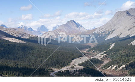 Alpine highway leading through valley with forest and surrounded with mountains, Jasper, Canada Alpine highway leading through valley with forest and surrounded with mountains, Jasper, Canada 91614629