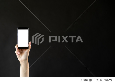 Mobile technology. Digital information. Advertising background. Female hand holding smartphone with blank white screen isolated black copy space. Mobile technology. Digital information. Advertising background. Female hand holding smartphone with blank white screen isolated black copy space. 91614829