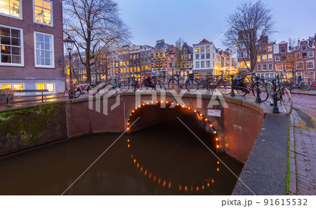 Beautiful old houses on the city waterfront of Amsterdam at sunset. 91615532