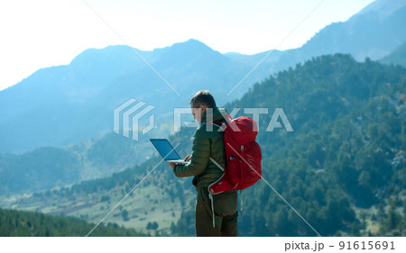 Men working outdoors with laptop in high mountains. Work online. Man works on laptop. Tourist with backpack. Mobile internet 91615691