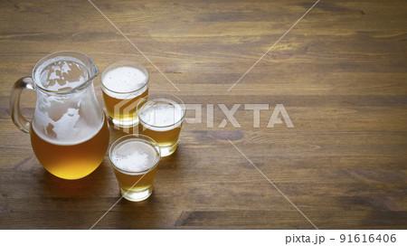 Beer in a pitcher and glasses on a wooden table Beer in a pitcher and glasses on a wooden table 91616406