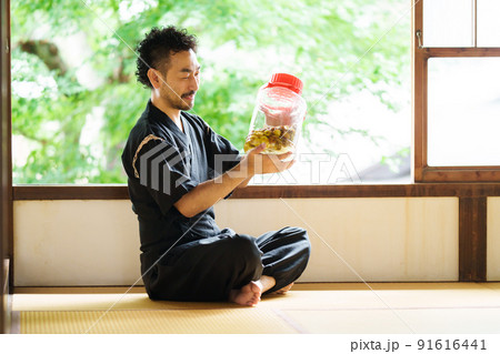 仕込んだ梅酒を眺める髭の男性 仕込んだ梅酒を眺める髭の男性 91616441