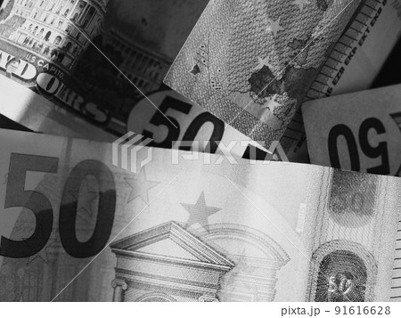 Paper banknotes in denominations of 50 dollars and 50 euros, a close-up shot. Black and white image. 91616628
