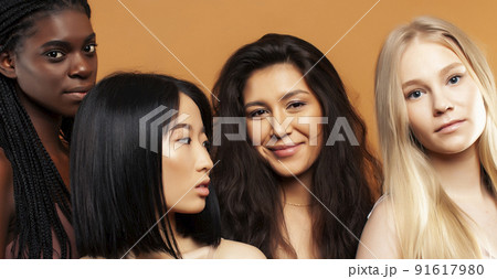 young pretty african and caucasian women posing cheerful together on brown background, lifestyle diverse nationality people concept close up young pretty african and caucasian women posing cheerful together on brown background, lifestyle diverse nationality people concept close up 91617980