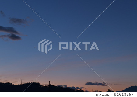 北杜市白州町、茜色の空に月齢27.6の細い月と並んだ金星 91618567