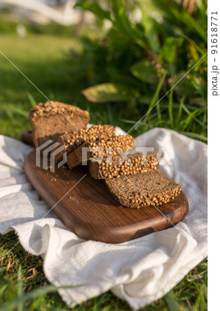 Composition of homemade custard bread on wood board with white cloth napkin on the green grass. High quality photo 91618771