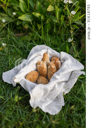 Composition of white flour buns in basket with white white cloth napkin on the green grass. High quality photo 91618793