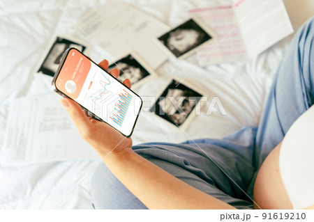 Pregnancy app. Mobile pregnancy online maternity application. Pregnant mother using phone. Pregnancy, medicine, pharmaceutics, health care and people concept. Pregnancy app. Mobile pregnancy online maternity application. Pregnant mother using phone. Pregnancy, medicine, pharmaceutics, health care and people concept. 91619210