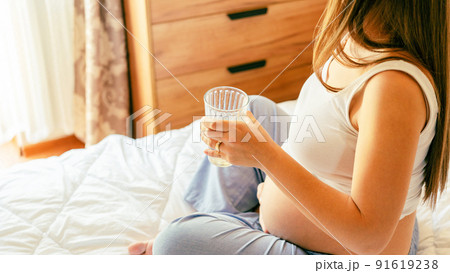 Drinking water pregnant woman. Young pregnancy mother drink water. Pregnant lady waiting of baby. Glass of water. Concept maternity, childbirth. Drinking water pregnant woman. Young pregnancy mother drink water. Pregnant lady waiting of baby. Glass of water. Concept maternity, childbirth. 91619238