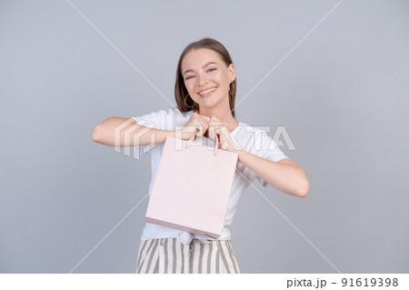 Cheerful beautiful girl holding shopping bag with place for mock up isolated Cheerful beautiful girl holding shopping bag with place for mock up isolated 91619398