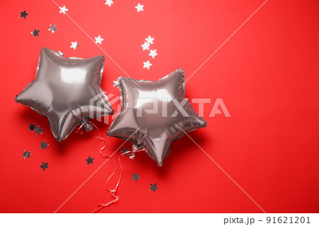 Star shaped pink balloons and confetti on red background, flat lay Star shaped pink balloons and confetti on red background, flat lay 91621201