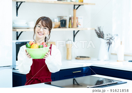 キッチンでサラダボウルを持つ女性 キッチンでサラダボウルを持つ女性 91621858