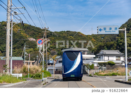 高知県室戸市　海岸沿いの室津港の横を走行中の観光バス 91622664