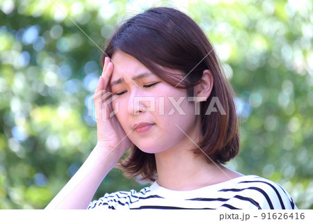 若い女性　体調不良　熱中症　めまい　頭痛　屋外　水分不足　 91626416