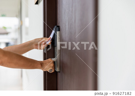 Female hand touch key card on hotel door. Female hand touch key card on hotel door. 91627182