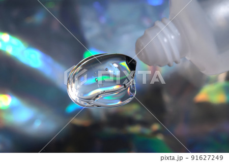 Hyaluronic gel or shower gel squeezed out of a bottle on a holographic background. Hyaluronic gel or shower gel squeezed out of a bottle on a holographic background. 91627249