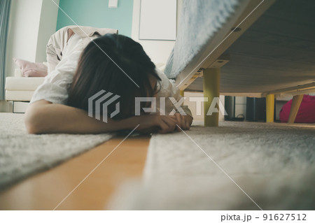 ベッドの下を覗き込む女性 ベッドの下を覗き込む女性 91627512
