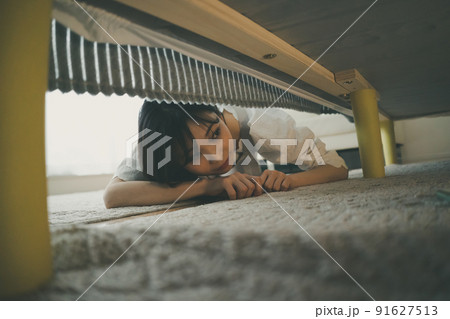 ベッドの下を覗き込む女性 91627513