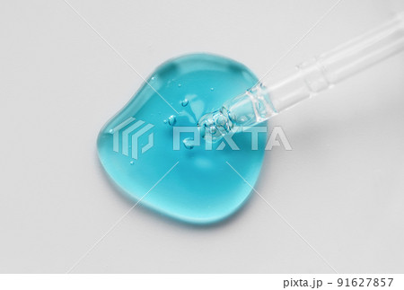 Pipette with blue gel, transparent fluid hyaluronic acid. Cosmetics, science and healthcare concept closeup. Dose of retinol. Front view, high angle shot. Beauty product closeup, banner 91627857