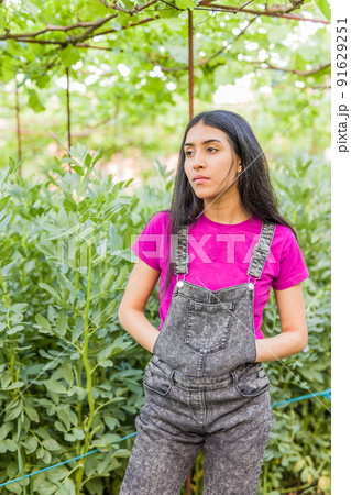 Venezuelan Latin young woman gardening and harvesting in urban garden portrait 91629251