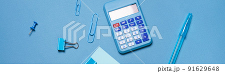 Calculator, stationery accessories on blue background with copy space. Look Calculator, stationery accessories on blue background with copy space. Look 91629648