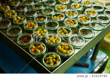 Filling of glass jars with pickled olives Filling of glass jars with pickled olives 91629780