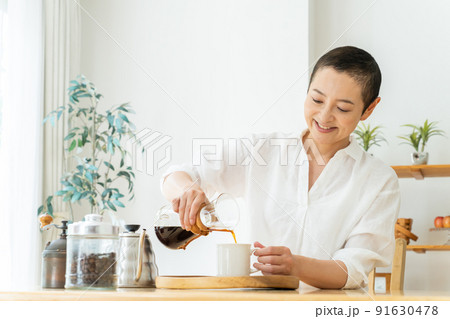 リビングでコーヒを入れるミドル女性 リビングでコーヒを入れるミドル女性 91630478